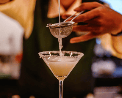 Barman pouring into a cocktail glass